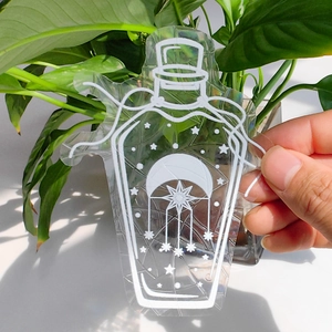 Close-up of a suncatcher window sticker featuring a moon and stars potion bottle design
