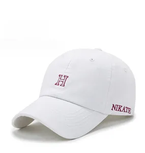 Gros plan détaillé du logo 'H' brodé en rouge 3D sur casquette en coton blanc