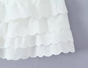 Gros plan sur la dentelle blanche multicouche et les détails de broderie florale