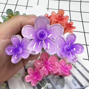 Detailed view of colorful translucent plumeria hair claws in purple, pink and green