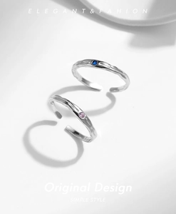 Detail of silver rings with hammer texture and blue and pink gemstone centerpieces