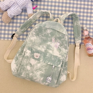 Detail of green and white tie-dye canvas backpack with cute bear embroidery and pocket