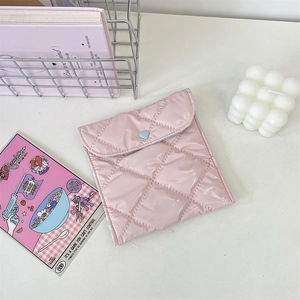 Detail of pink quilted sanitary bag with heart buckle in a stylish lifestyle setting