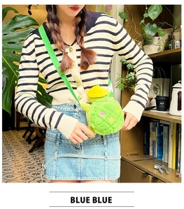 Detail of plush turtle crossbody bag with yellow hat and adjustable green shoulder strap