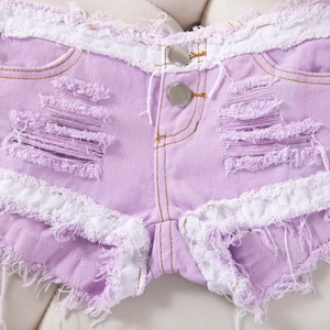 Primer plano detallado de pantalones cortos vaqueros morados con rotos y dobladillo