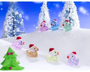 Close-up of colorful resin ducks with glitter and Santa hats on snowy decorative background