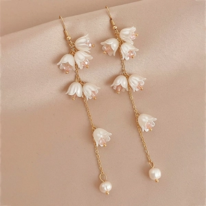 Boucles d'oreilles muguet élégantes avec pétales blancs et perles sur satin champagne