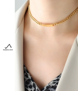 Detailed close-up of a 18k gold plated stainless steel Cuban link necklace on a model
