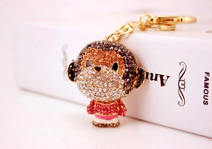 Close-up of cute golden monkey keychain with sparkling brown and pink rhinestones