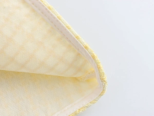 Dettaglio del tessuto tweed a quadri gialli con bordo profilato bianco della gonna