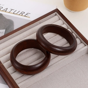 Polished dark sandalwood bangles with natural grain in a vintage minimalist style
