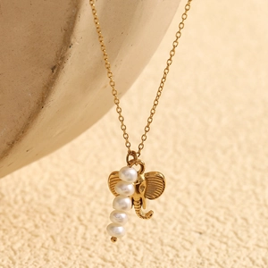 Macro detail of elephant head pendant with four white pearls on a gold-plated chain