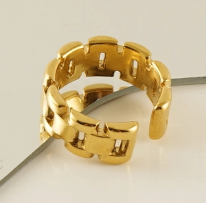Detailed close-up of a geometric chain-link gold open ring on a minimalist background