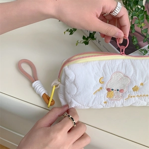 Detail of cute embroidered rabbit on white quilted pencil case with dual pink zippers