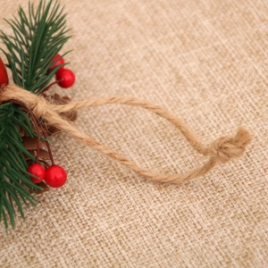 Detailed macro shot of Christmas bell pendant with red berries and natural pinecones