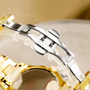 Detailed macro view of diamond-encrusted gold and silver watch band with butterfly clasp