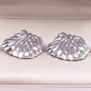 Detailed macro view of 304 stainless steel earrings with irregular seashell texture finish