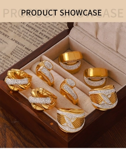 Muestra de anillos cruzados chapados en oro y bandas texturizadas con circonitas