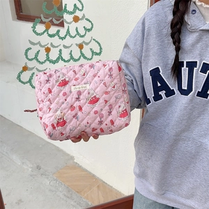 Détail de la trousse de maquillage rose matelassée avec imprimés lapin et étiquette
