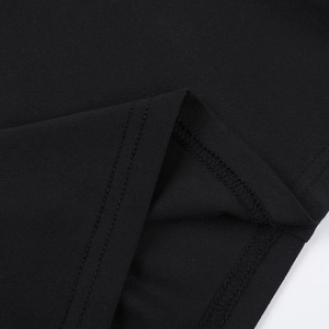 Close-up of double-needle stitching and fine knit texture on the hem of a black dress