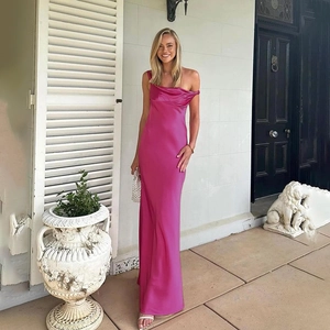 Détail d'une robe longue en satin fuchsia élégante avec un décolleté drapé et brillant