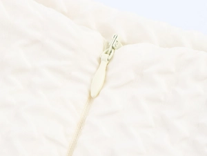 Détail d'une fermeture éclair invisible crème sur un ensemble en tissu gaufré