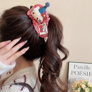 Detailed view of a red plaid scrunchie with a plush Hello Kitty character on a ponytail