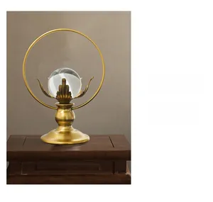 Detail of a lotus crystal ball on a golden metal ring stand with a solid wood base