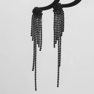Luxurious long black rhinestone tassel earrings hanging on a modern display stand