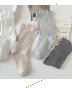 Flat lay of soft cotton crew socks in white, beige, blue, and grey with ribbed cuffs
