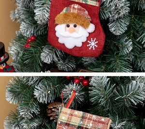 Detail of burlap Christmas stockings with Santa applique and tartan plaid pattern