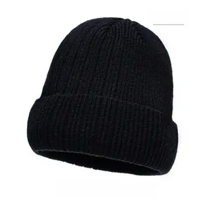Close-up of black ribbed knit beanie with brown leather patch detail and folded brim