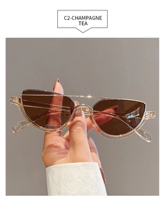 Detail of semi-rimless champagne cat eye sunglasses with gold metal top bar and tea lenses