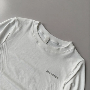 Close-up of white yoga top featuring side ribbing and a round neckline for workout