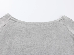 Macro shot of the stitching and fabric texture on a grey off-shoulder minimalist T-shirt