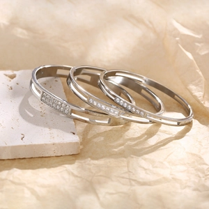 Detailed view of silver stainless steel stackable bangles with zircon stone inlay
