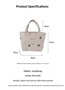 Detail view of beige corduroy handbag with bear embroidery showing inner pocket and capacity