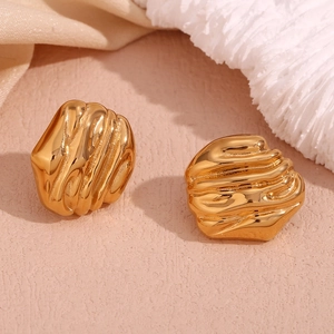 Macro shot of gold irregular geometric earrings with textured lava pattern finish