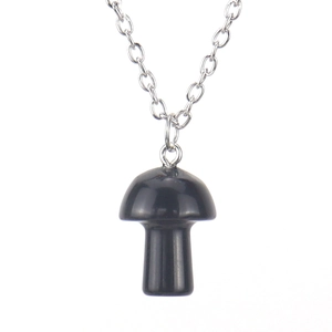 Macro view of a 2cm polished black mushroom pendant on a delicate silver metal chain link