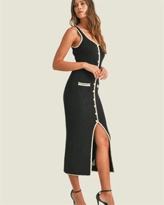 Detail of black knit midi dress with white contrast trim and side slit design