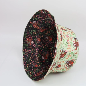 Detailed view of reversible sloth pattern bucket hat showing both green and black floral sides
