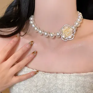 Close-up of multi-layer pearl necklace with sparkling diamond flower pendant detail