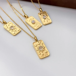 Detail of tarot card pendants with sun, moon, and star charms in 18K gold plated steel