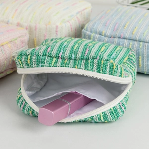 Detailed close-up of rainbow striped woven cosmetic bags with open view of interior
