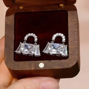 Silver bag-shaped earrings with sparkling cubic zirconia set in a premium wood jewelry box
