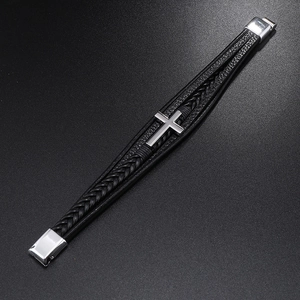Detail of multi-layer black leather woven bracelet with silver cross and magnetic clasp