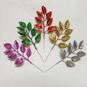 Close-up of glittered artificial leaves in purple green red gold and silver for DIY decor