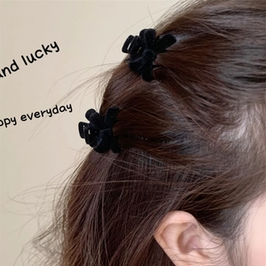 Pair of vintage velvet bow hair clips styled on long brown hair for a princess look
