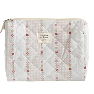 Quilted floral makeup bag with vertical stripes and zipper closure in pastoral style