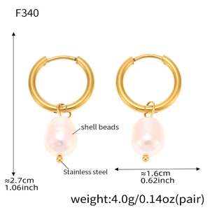 Close-up of golden stainless steel hoop earrings with pink teardrop shell bead pendants